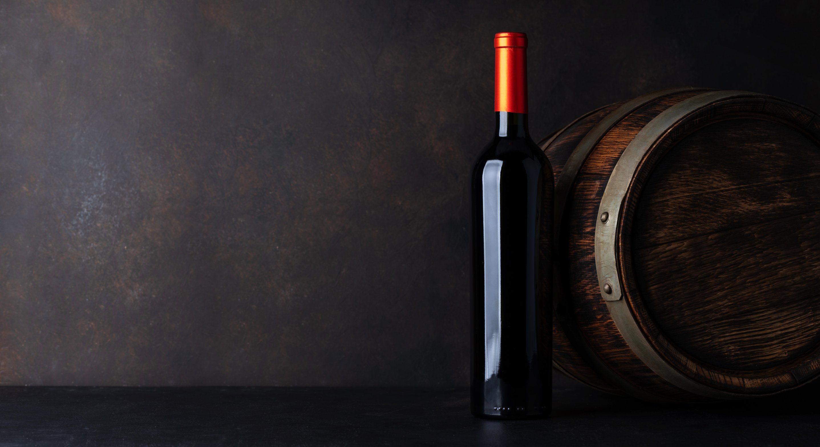 Red wine bottle and old wine barrel